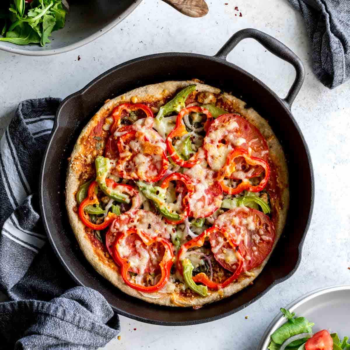 Overhead of homemade pizza in a cast iron skillet.