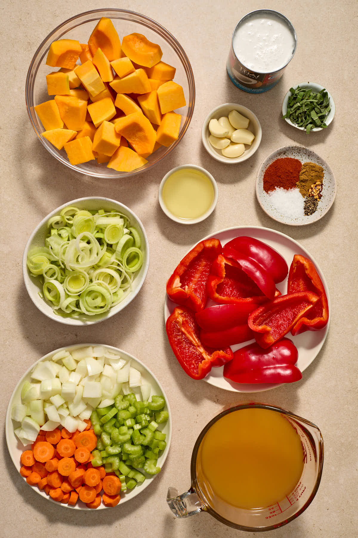 Ingredients for roasted red pepper and butternut squash soup arranged in individual dishes.