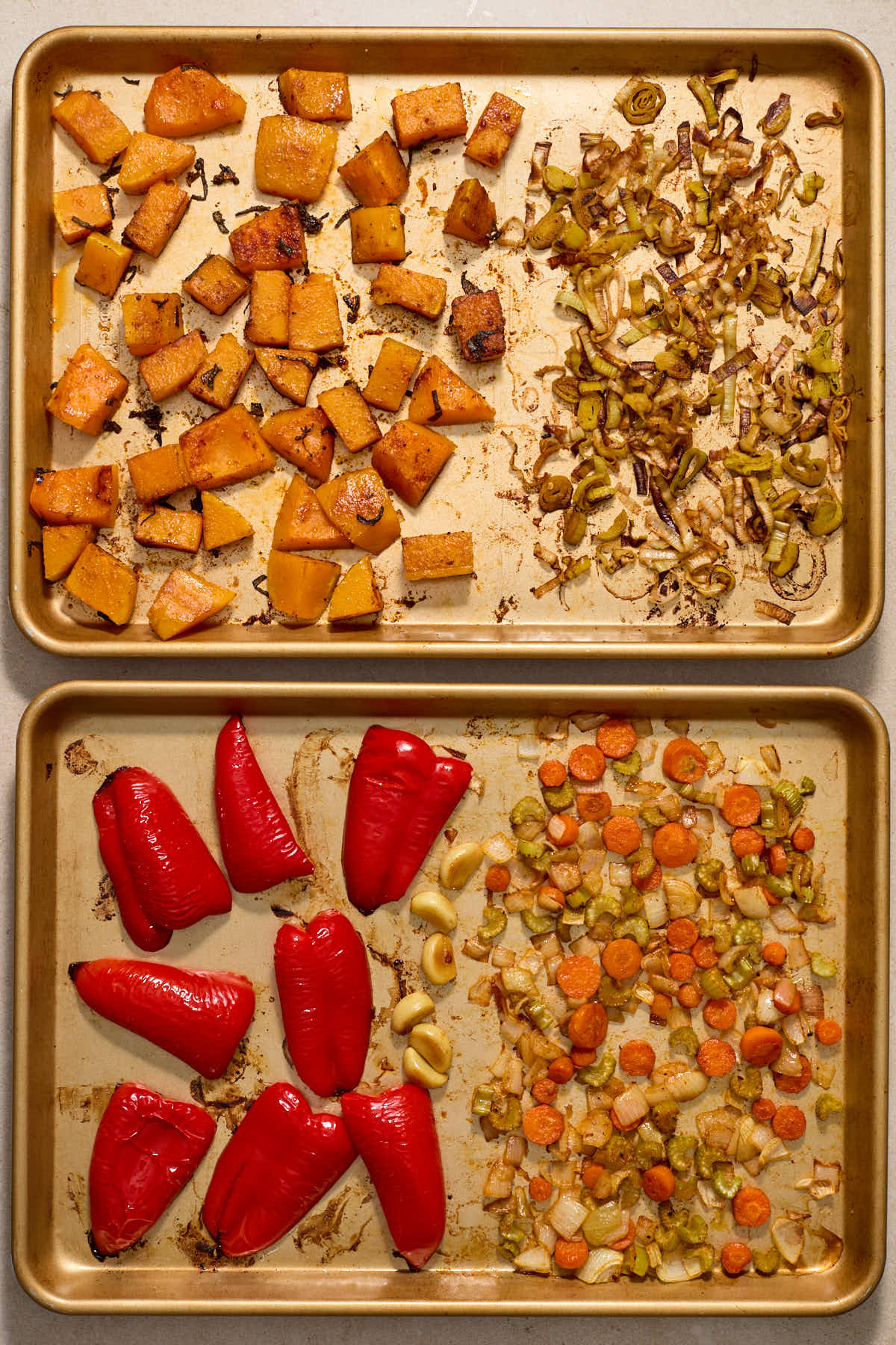 Roasted squash, red peppers and other vegetables on two sheet pans.