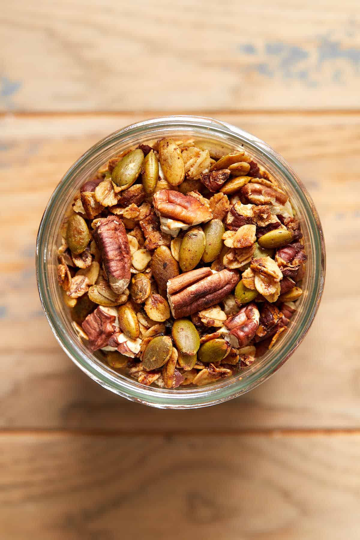 Overhead view of savory granola in a glass jar.