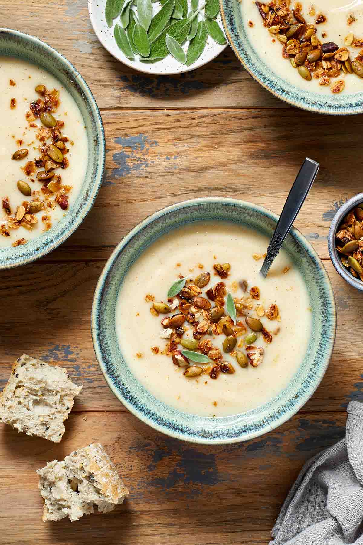 Savory granola on tops of bowls of parsnip soup.