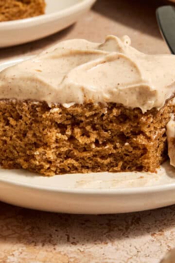 A piece of vegan chai spice cake on a plate with a forkful removed.