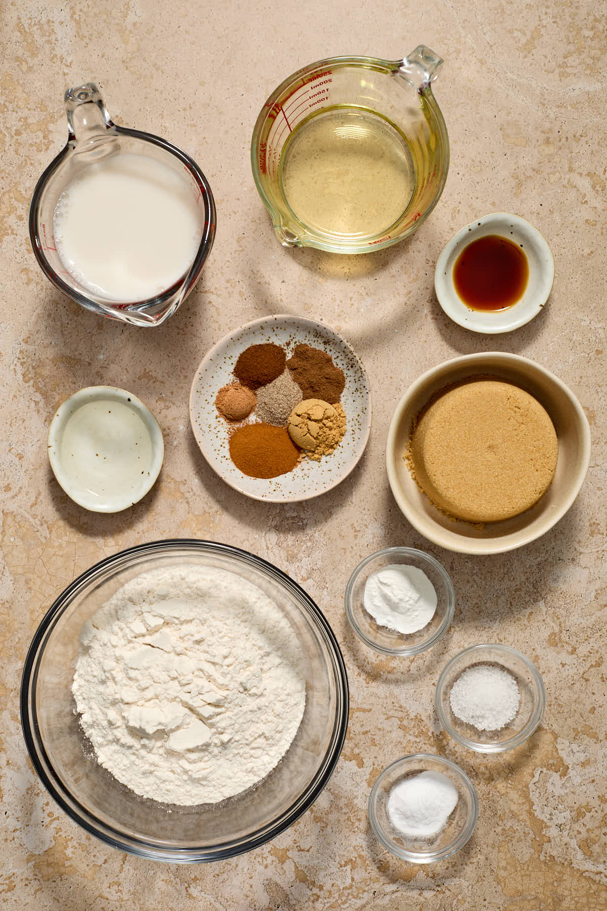 Ingredients to make chai spice cake arranged in individual dishes.