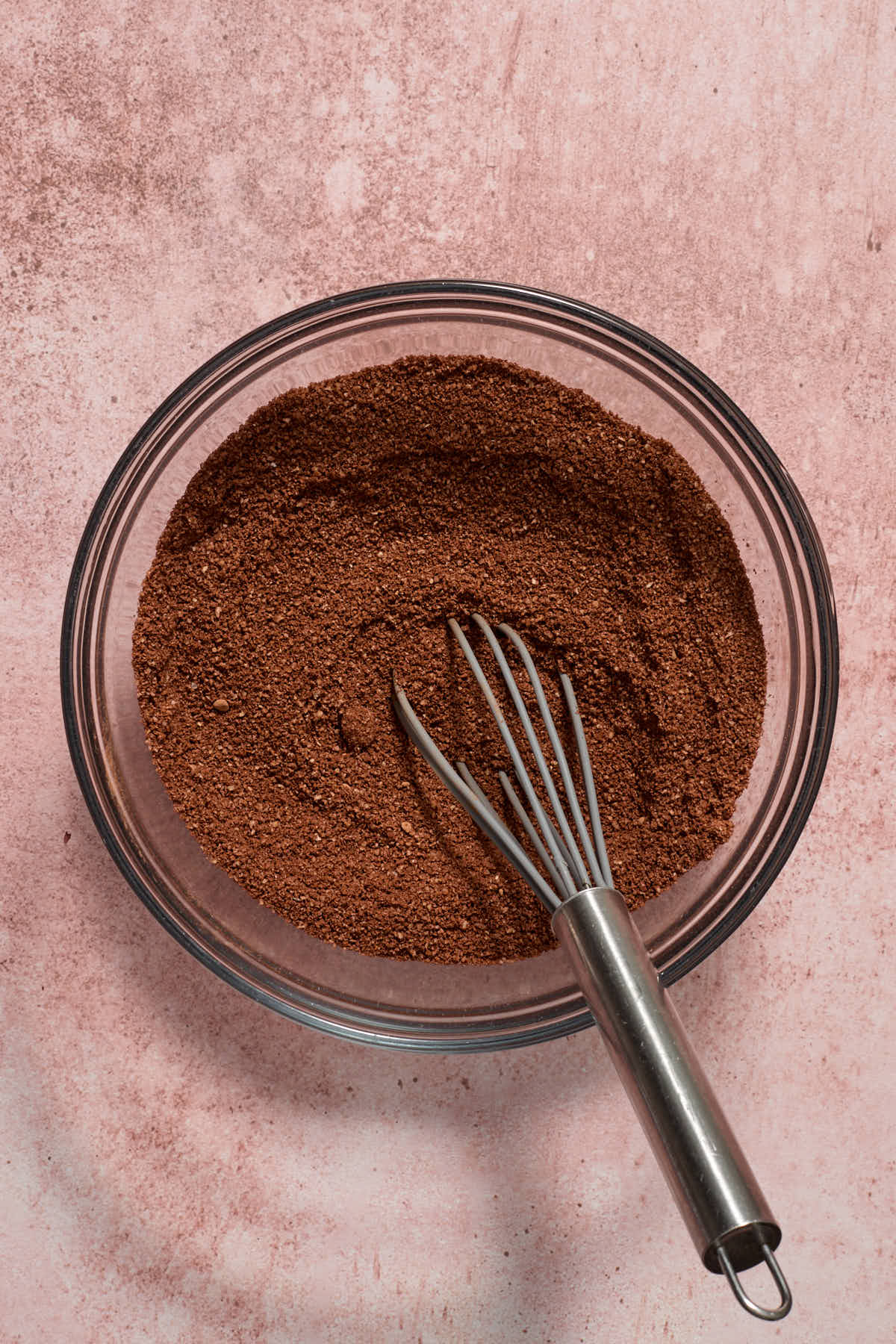 Almond flour, cocoa, baking soda and salt stirred together in a glass bowl with a whisk.