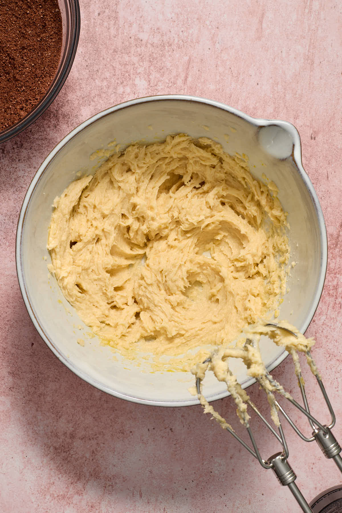 All of the wet ingredients mixed together in a white bowl with the bowl of dry ingredients on the side.