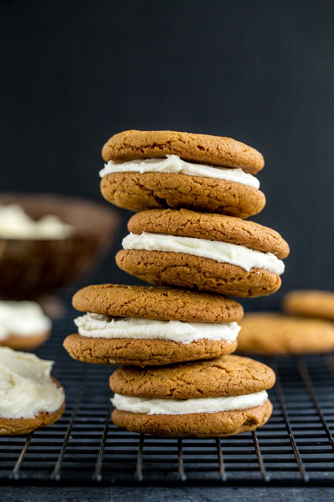 Side view of a stack of chewy ginger cookies with lemon cream cheese frosting.