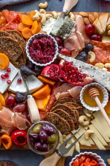 Overhead of a holiday charcuterie on a large wooden cheese board.