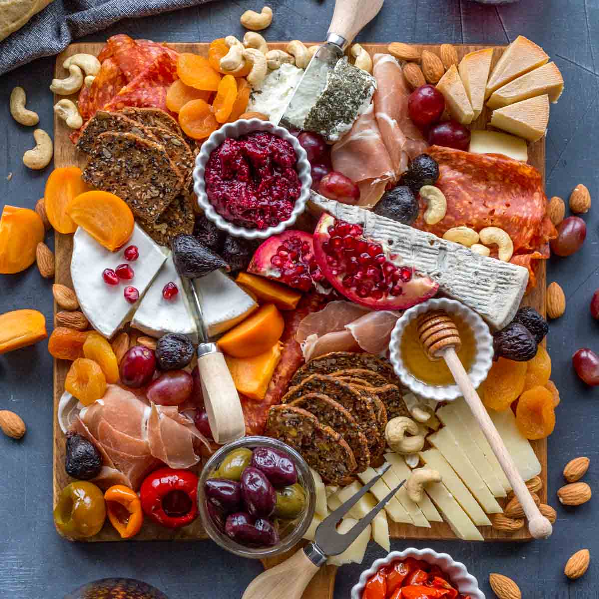 Overhead of a holiday charcuterie on a large wooden cheese board.