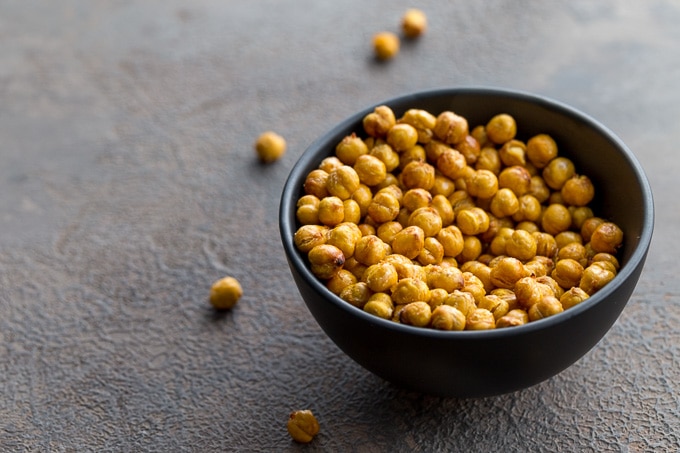 Air fryer chickpeas in a black bowl on a grey surface.