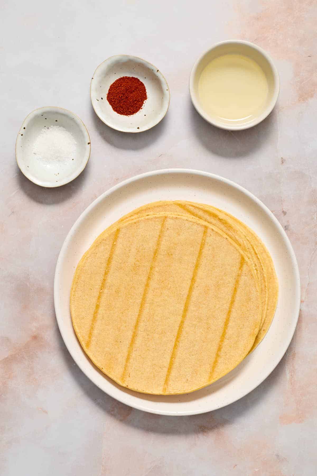 Ingredients to make air fryer tortilla chips arranged individually on a surface.