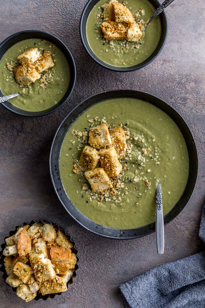 Vegan sweet pea soup served up in bowls with croutons.