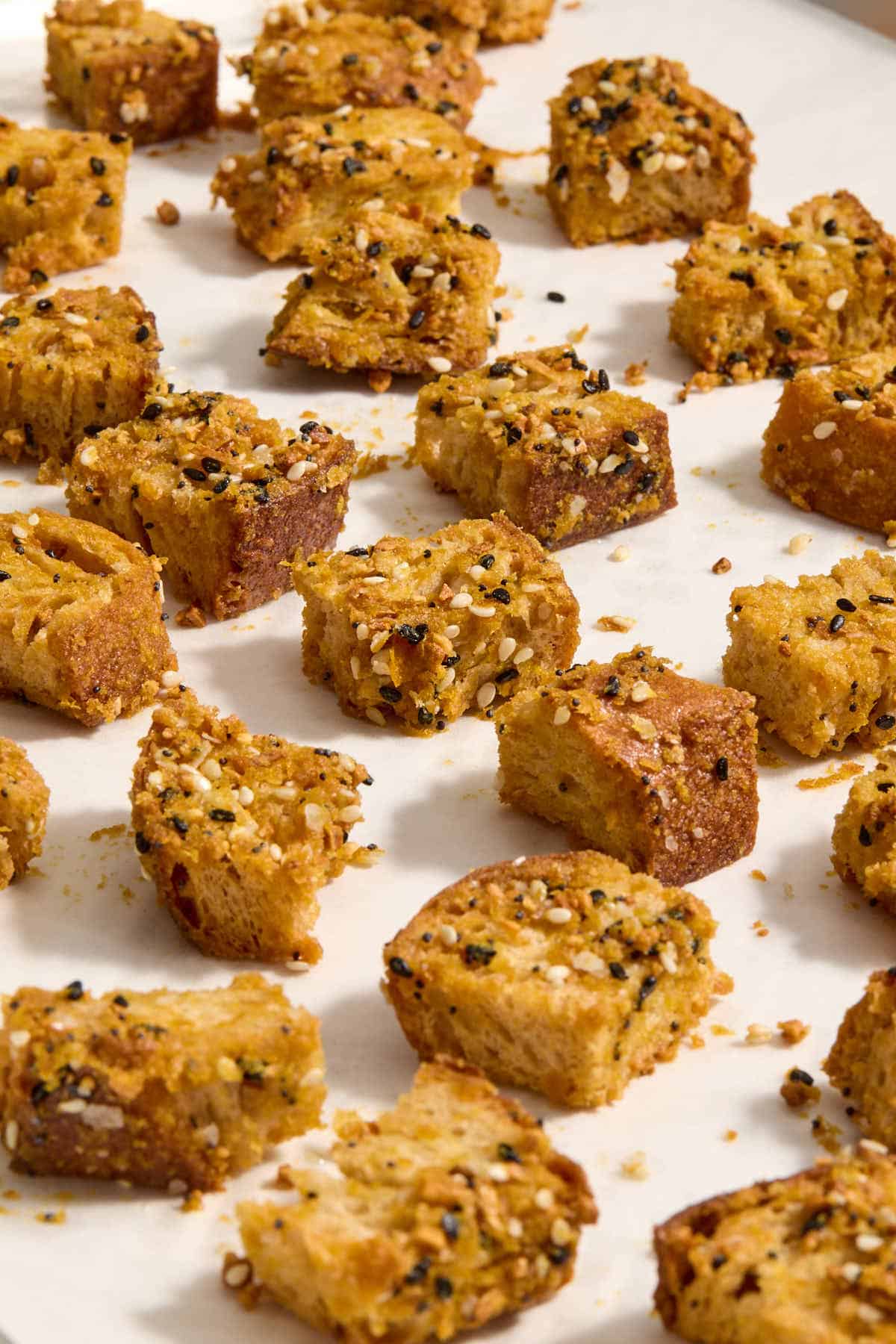 Croutons spread out on a baking sheet.