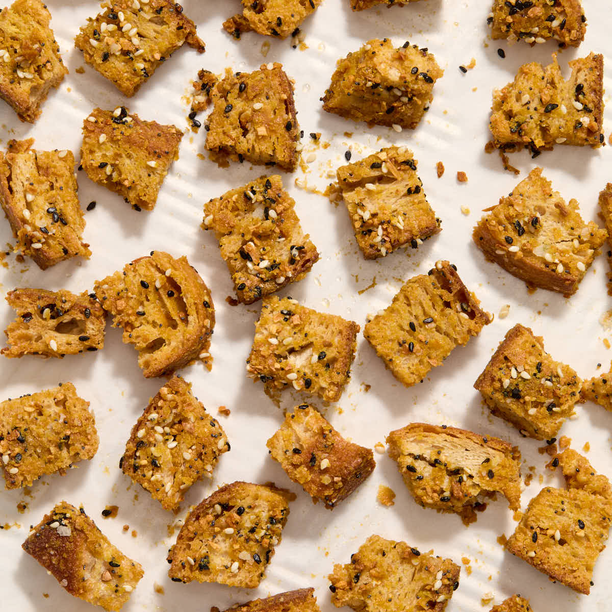 Baked croutons cooling on a baking sheet.