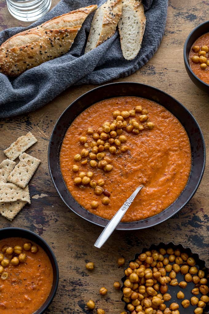 Up-close view of Tomato Chickpea Soup in a black bowl and topped with chickpeas.