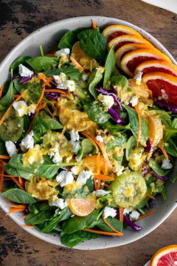 Overhead of winter citrus salad in a large bowl and topped with dressing.