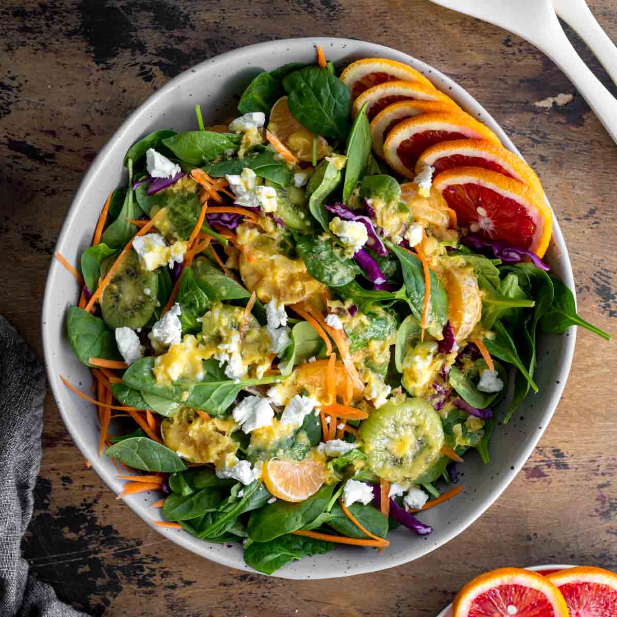 Overhead of winter citrus salad in a large bowl and topped with dressing.
