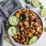 Air Fryer Baby Potatoes piled on a plate with dips and jalapeno slices.
