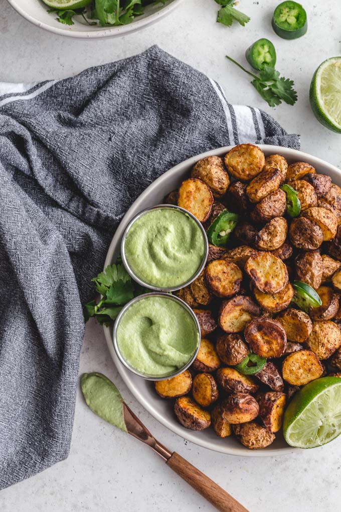Air fryer roasted potatoes served on a plate with jalapeno dip.