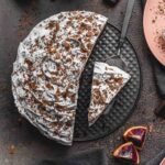 Overhead of blood orange chocolate cake with slices being removed.