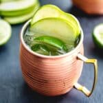 Green apple Irish mule with apple slices and lime wedge on top.