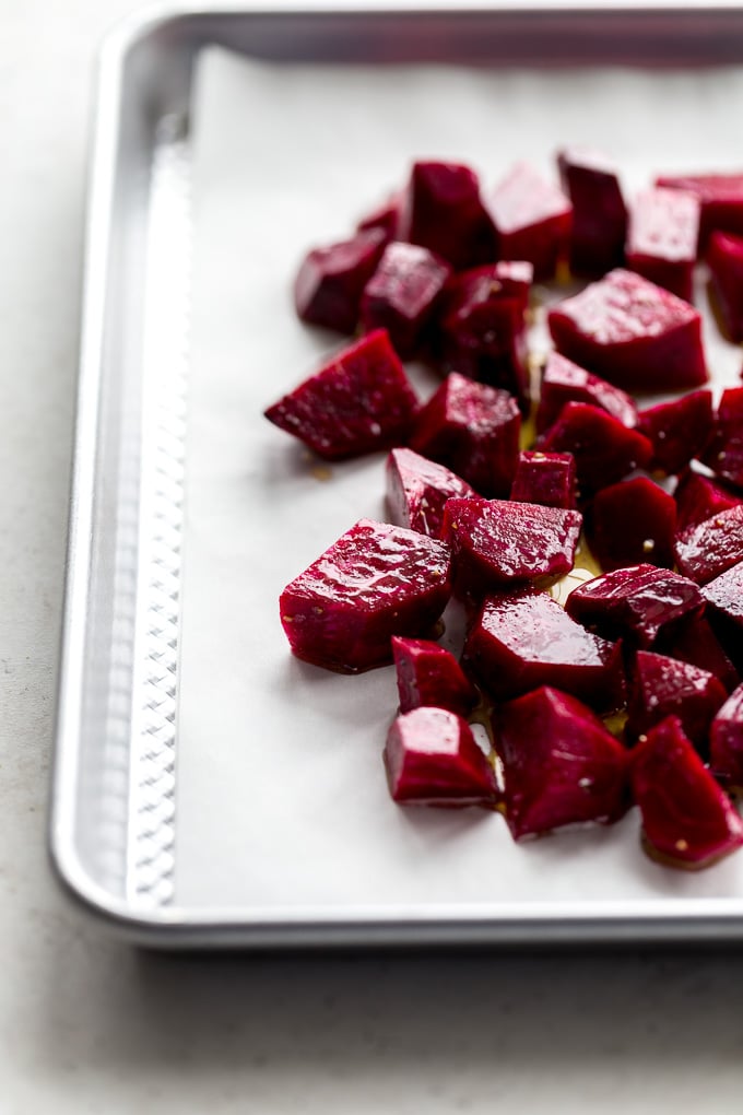 Side view of chopped fresh beets on a baking sheet.