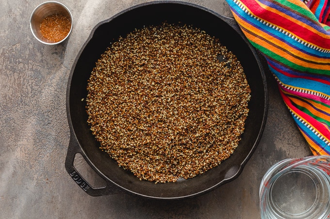 Overhead view of toasted quinoa in a cast iron pan.