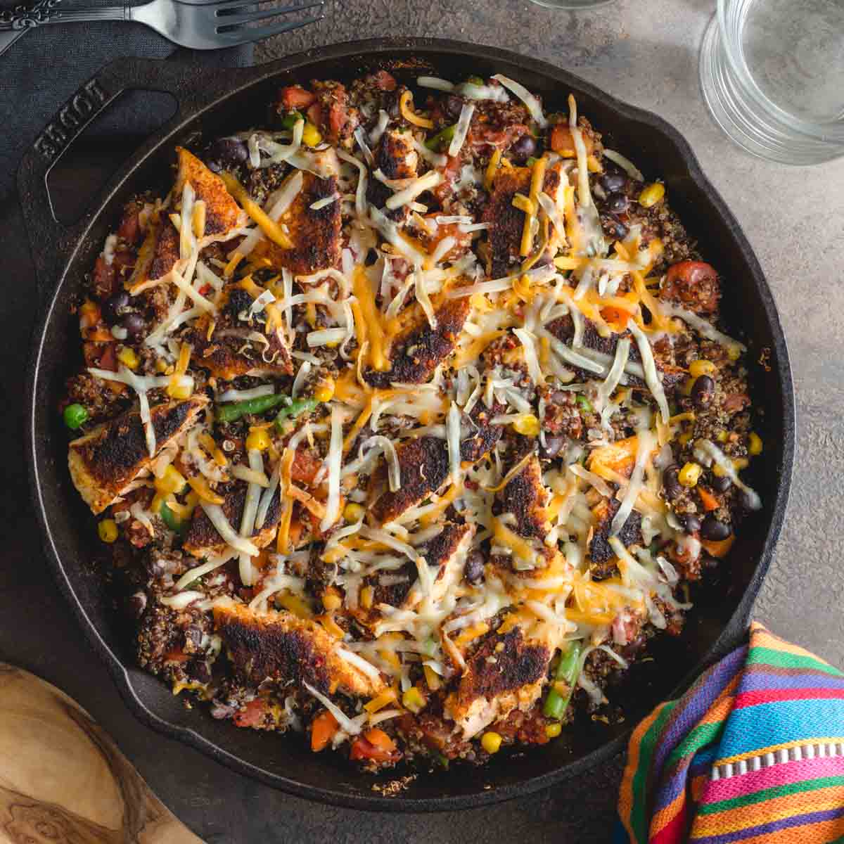 Overhead of salmon quinoa bake in a cast iron skillet with a wooden spoon on the side.
