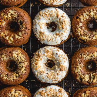 Carrot Cake Donuts arranged closely together on a wire rack.