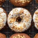 Overhead close up of carrot cake donuts on a wire cooling rack.