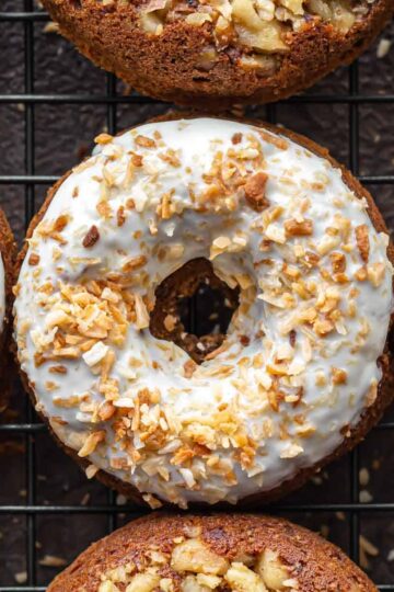 Overhead close up of carrot cake donuts on a wire cooling rack.