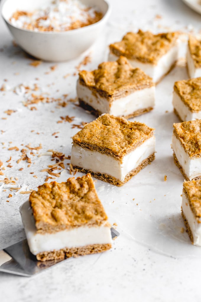 Carrot cake ice cream sandwiches cut into squares and arranged on a light surface.