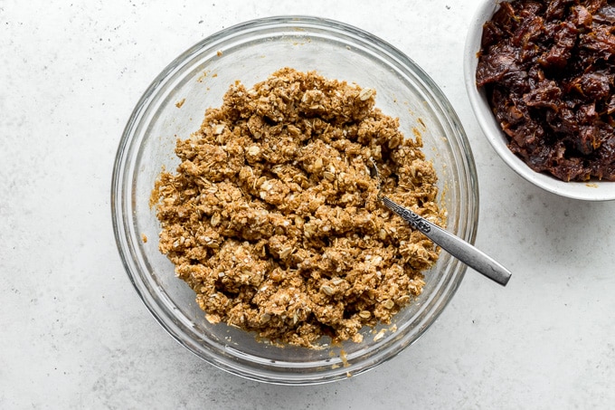 Oat mixture in a glass bowl with date filling off to the side.