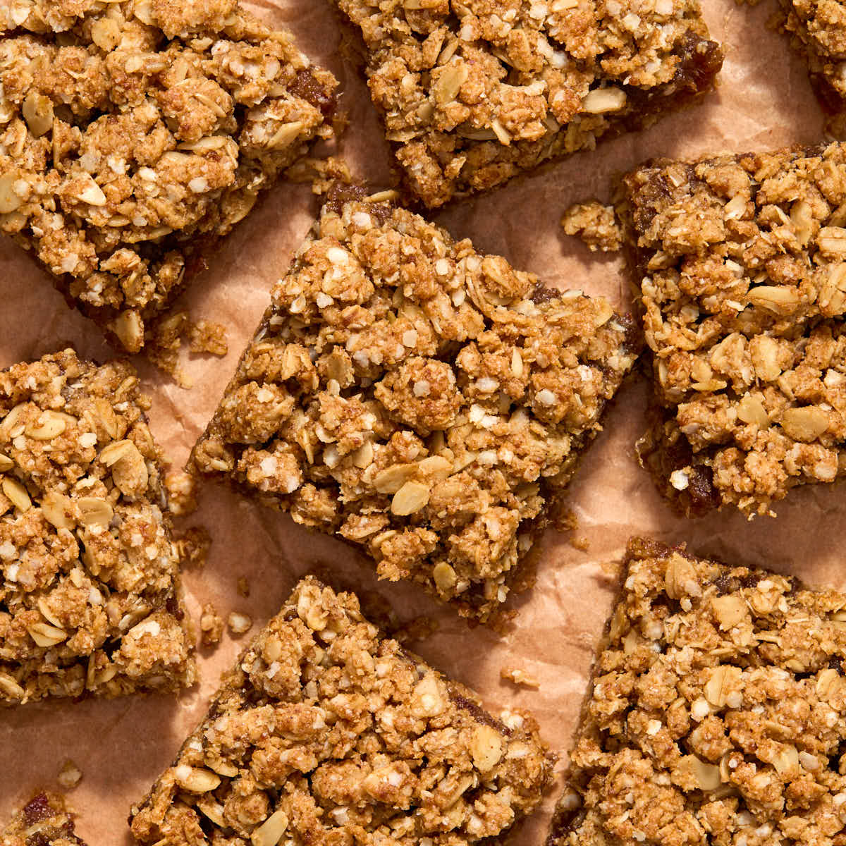 Date squares cut into bars on brown parchment paper.