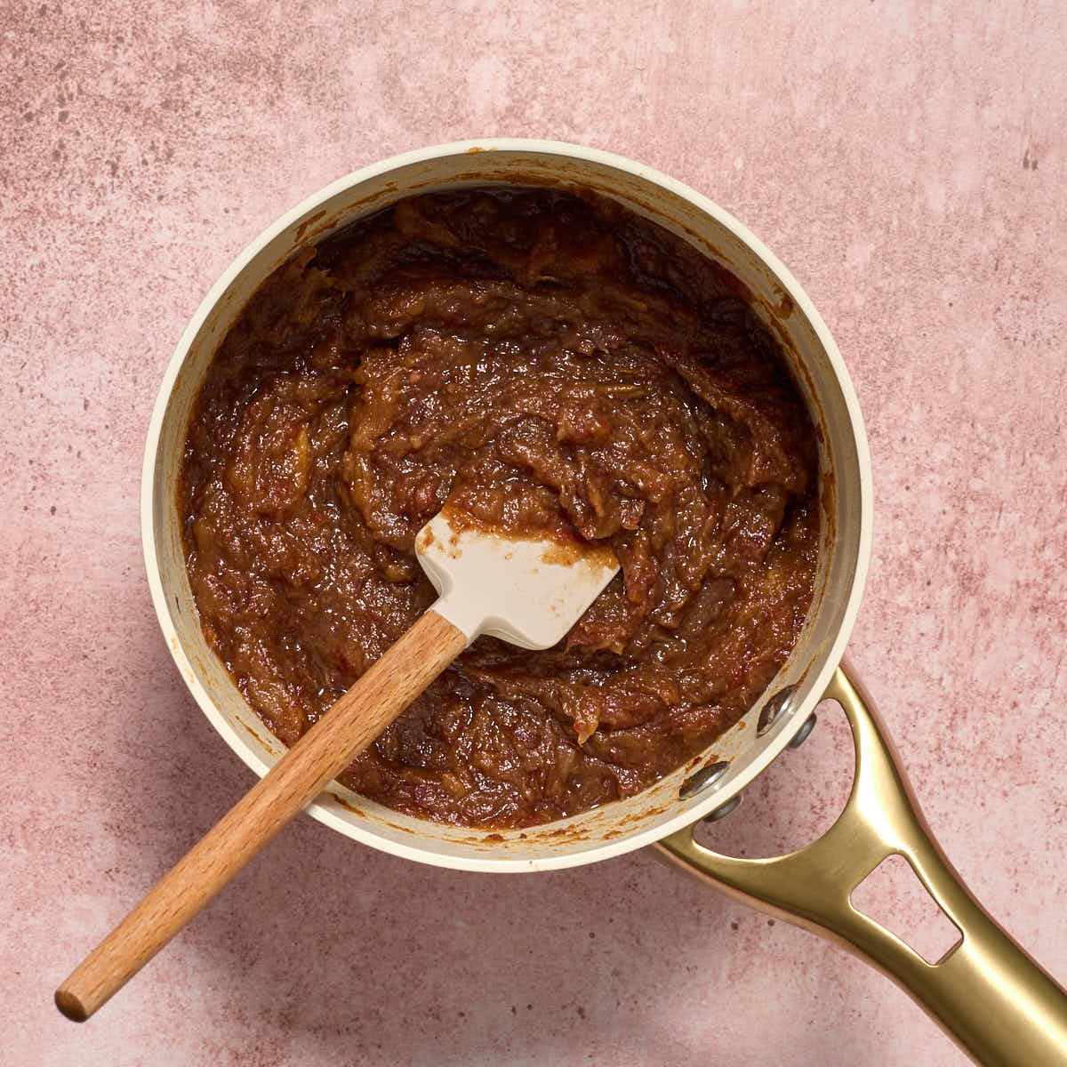 Date filling cooked in small sauce pan with a spatula in it.