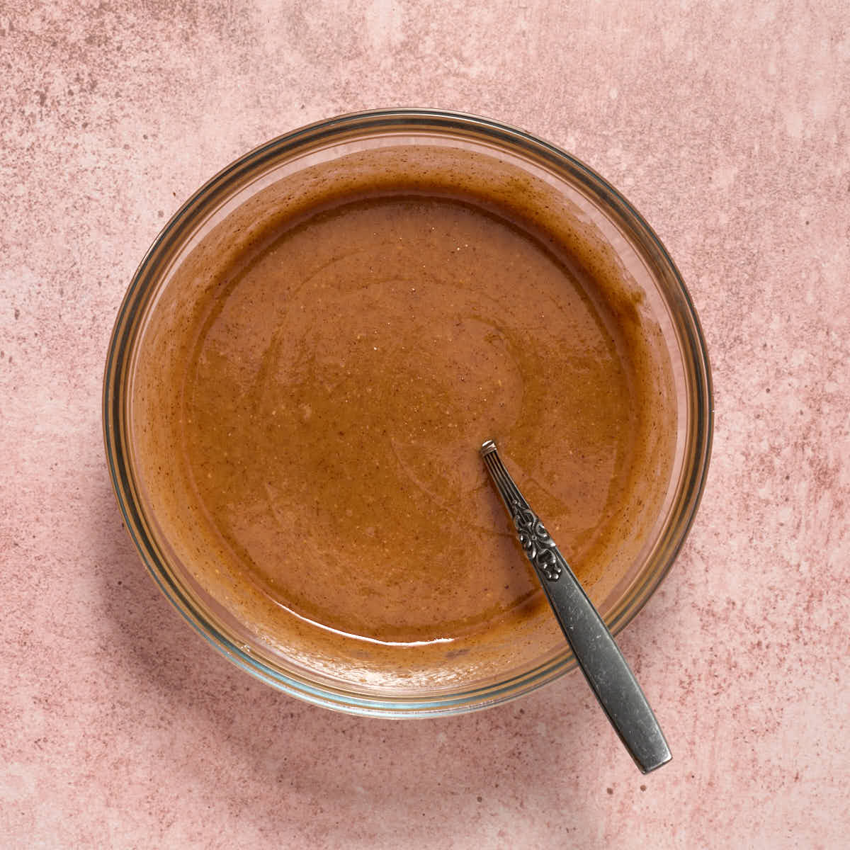 Almond butter, maple syrup and coconut oil melted together in a bowl.