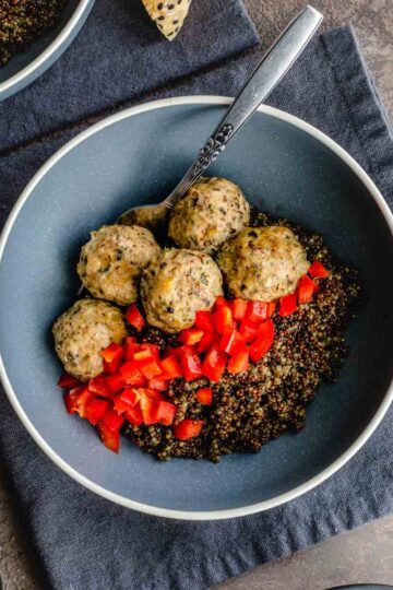 Overhead of ground turkey meatballs and quinoa served in a blue bowl.