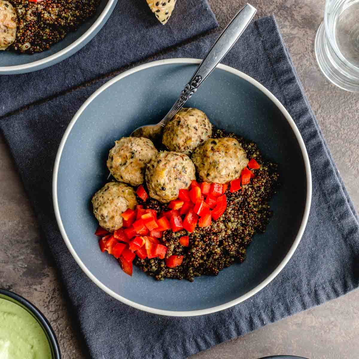 Overhead of ground turkey meatballs and quinoa served in a blue bowl.