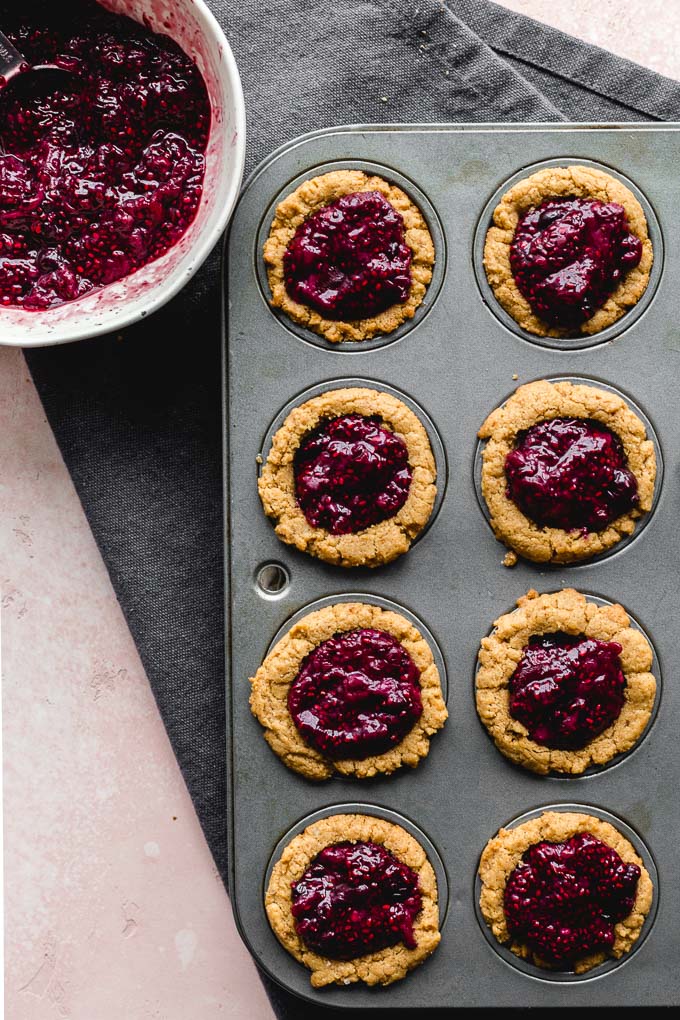Cookie cups in a mini muffin pan and filled with chia jam.