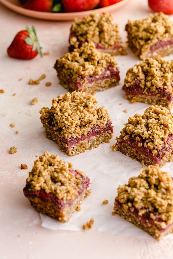 Strawberry oatmeal bars with strawberries in the background.