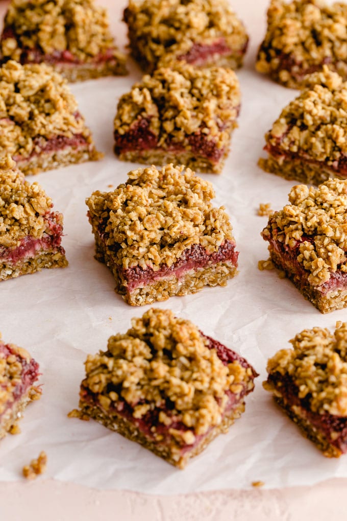 Strawberry oat bars arranged on a sheet of parchment paper.