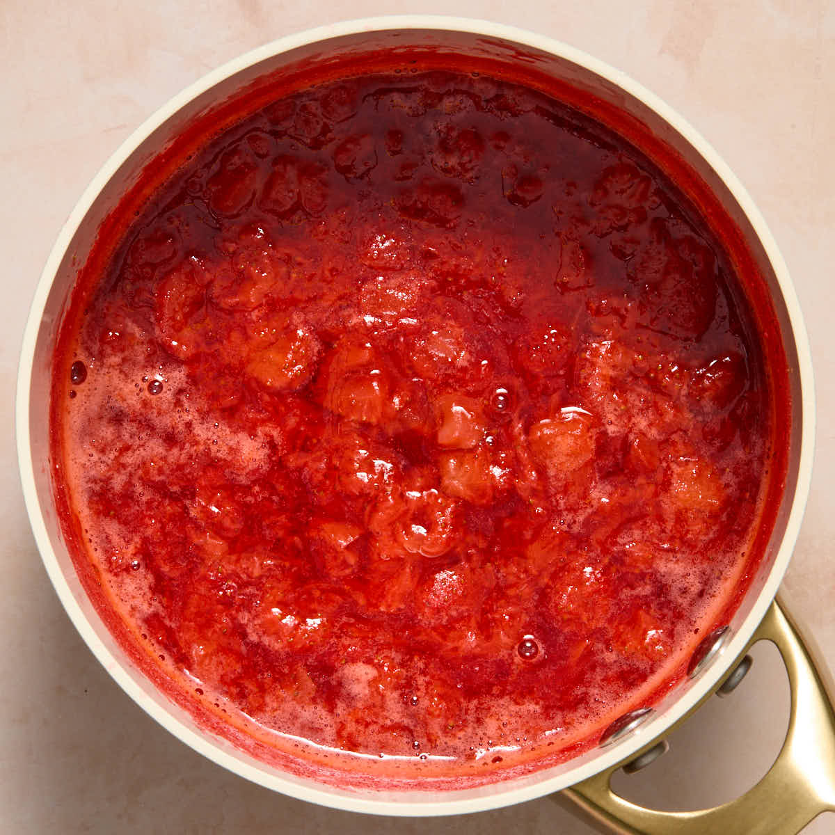 Cooked and mashed strawberries in a sauce pan.