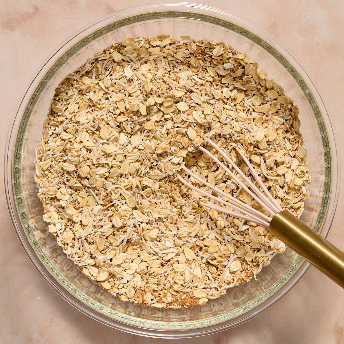 Dry oat mixture whisked together in a glass bowl.