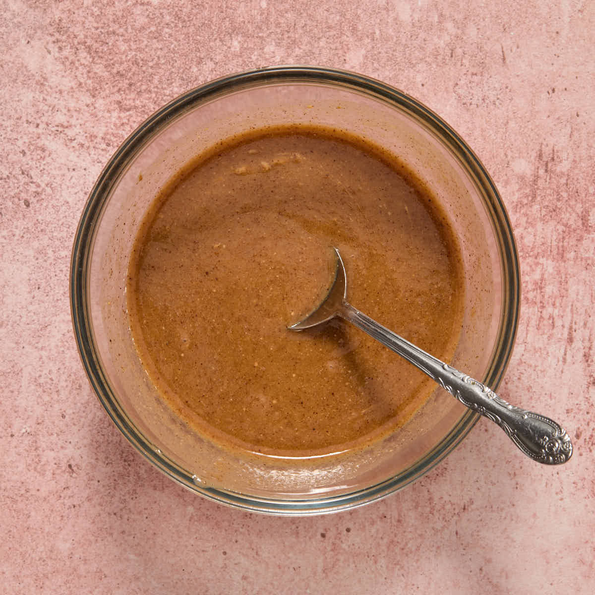 Melted almond butter mixture stirred together in a glass bowl.