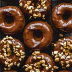 Protein donuts topped with chocolate peanut butter glaze and chopped peanuts.
