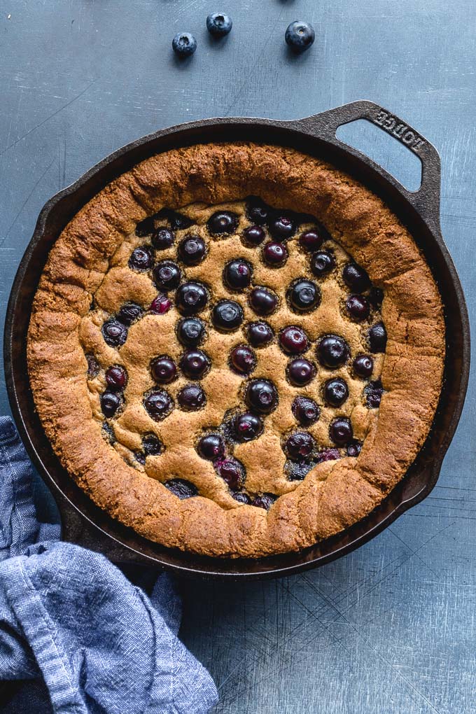Gluten-free skillet cookie with blueberries baked into the top.