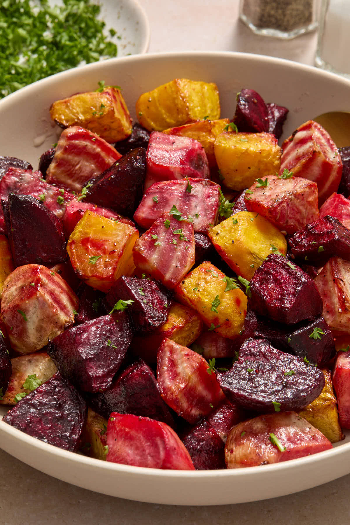 Air fried beets in a bowl with chopped parsley sprinkled on top.