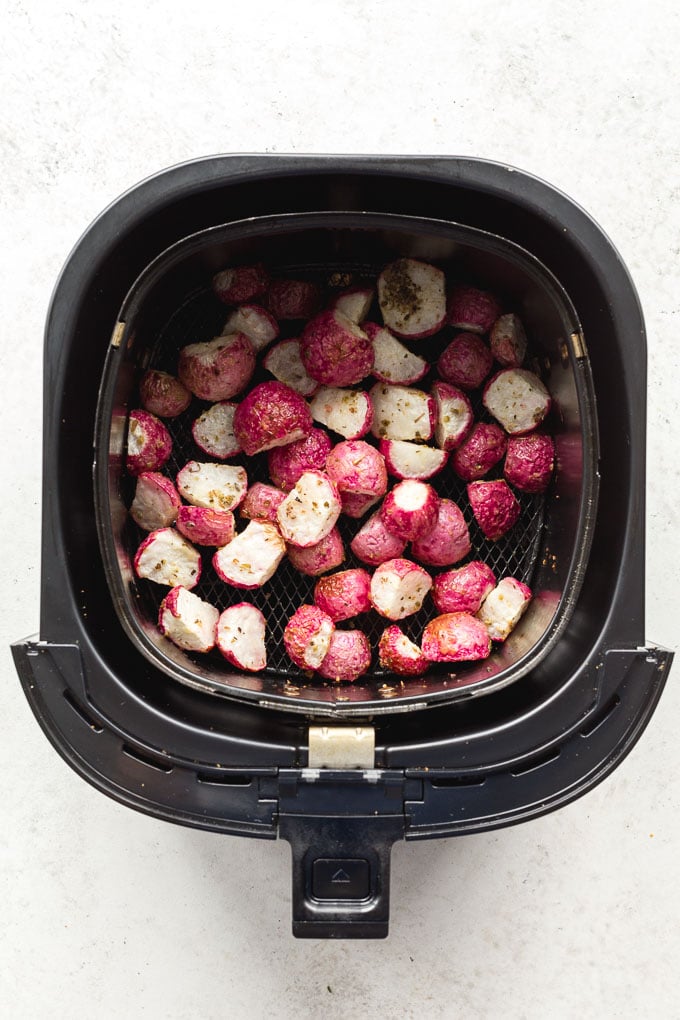 Overhead view of roasted radishes in the air fryer basket.