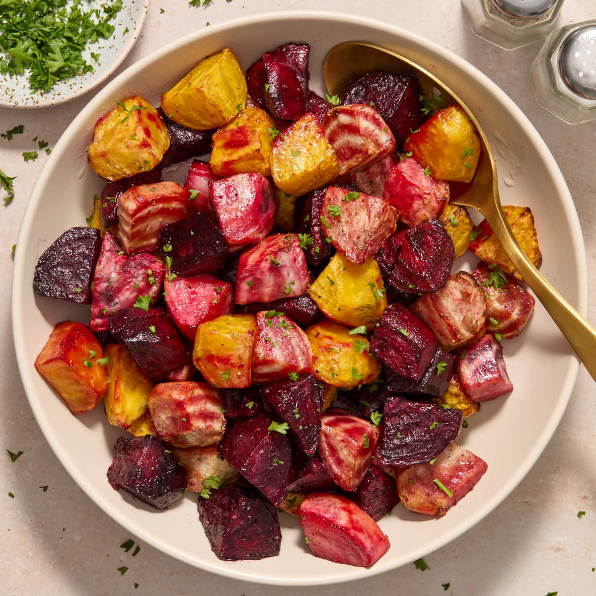 Air fryer beets served in a white bowl with a serving spoon in the bowl.