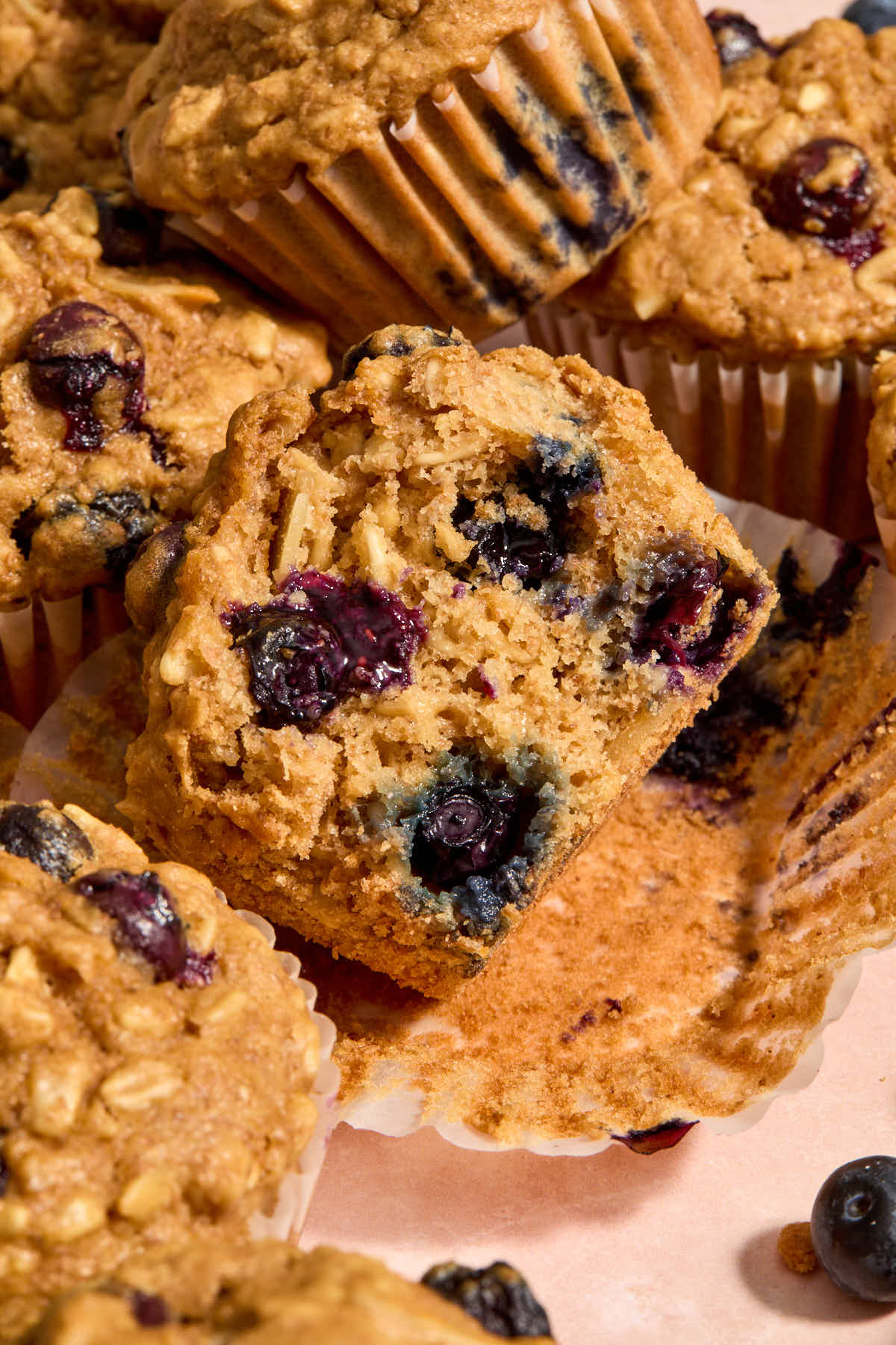 Half of a muffin tipped on its side on a muffin wrapper.