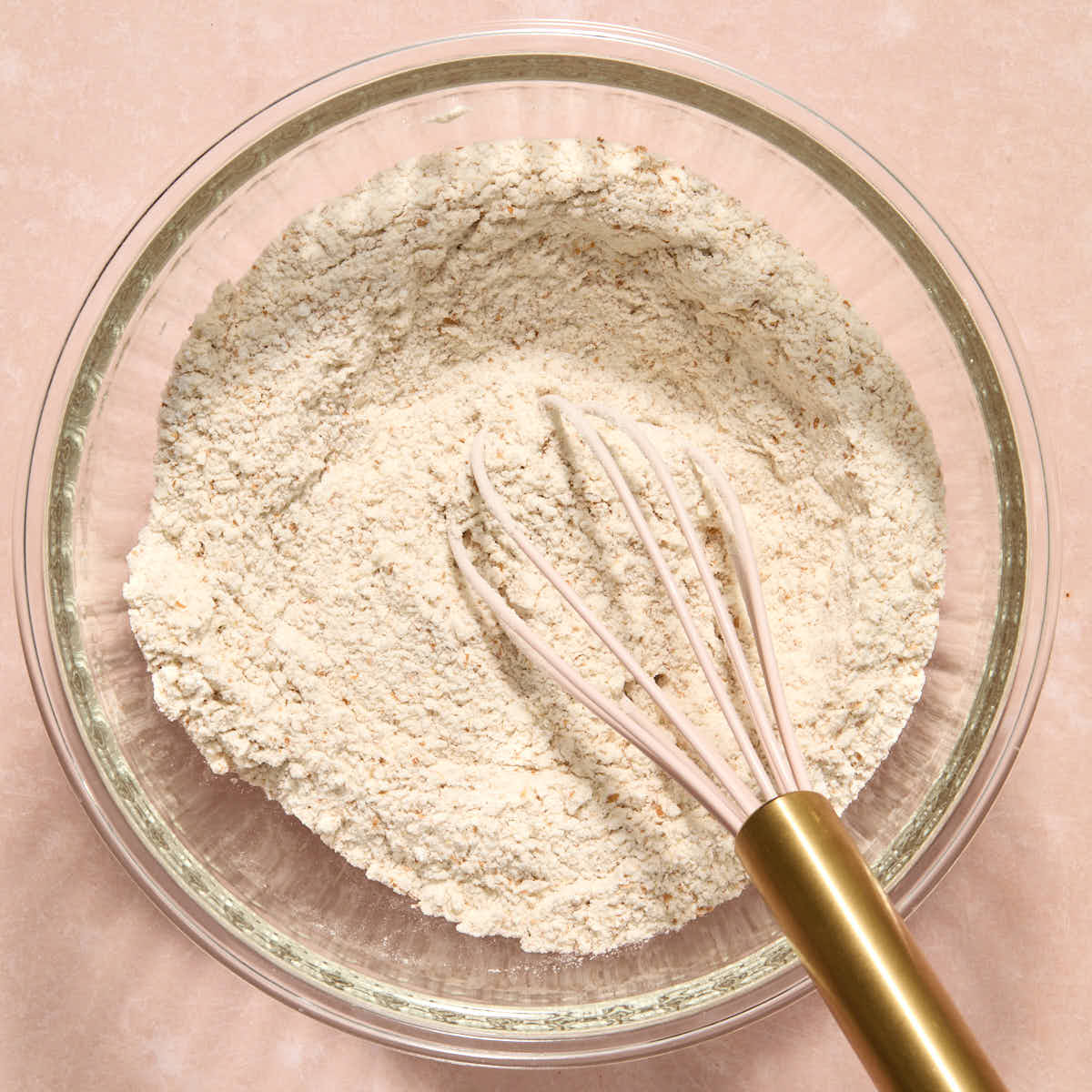 Dry batter ingredients whisked together in a glass bowl.
